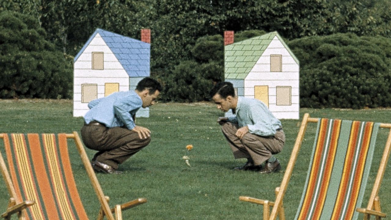 two men next to two houses and two cots